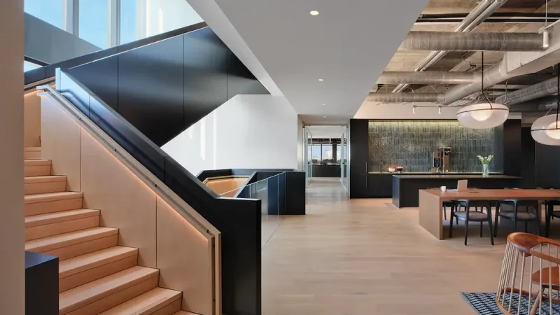 a modern office interior featuring wooden stairs and a sleek design